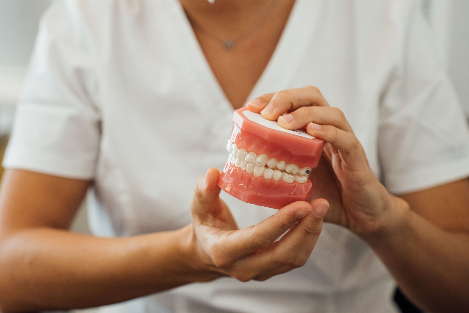 partial view of a nurse holding dentures in hands 2023 11 27 05 06 59 utc scaled