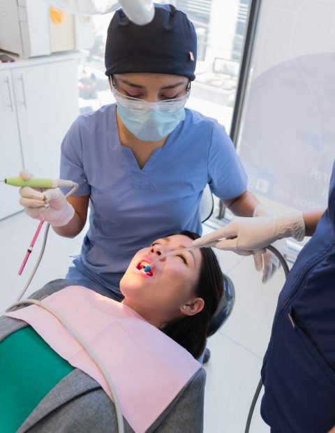 Young female dentist performed dental procedure to a female patient.